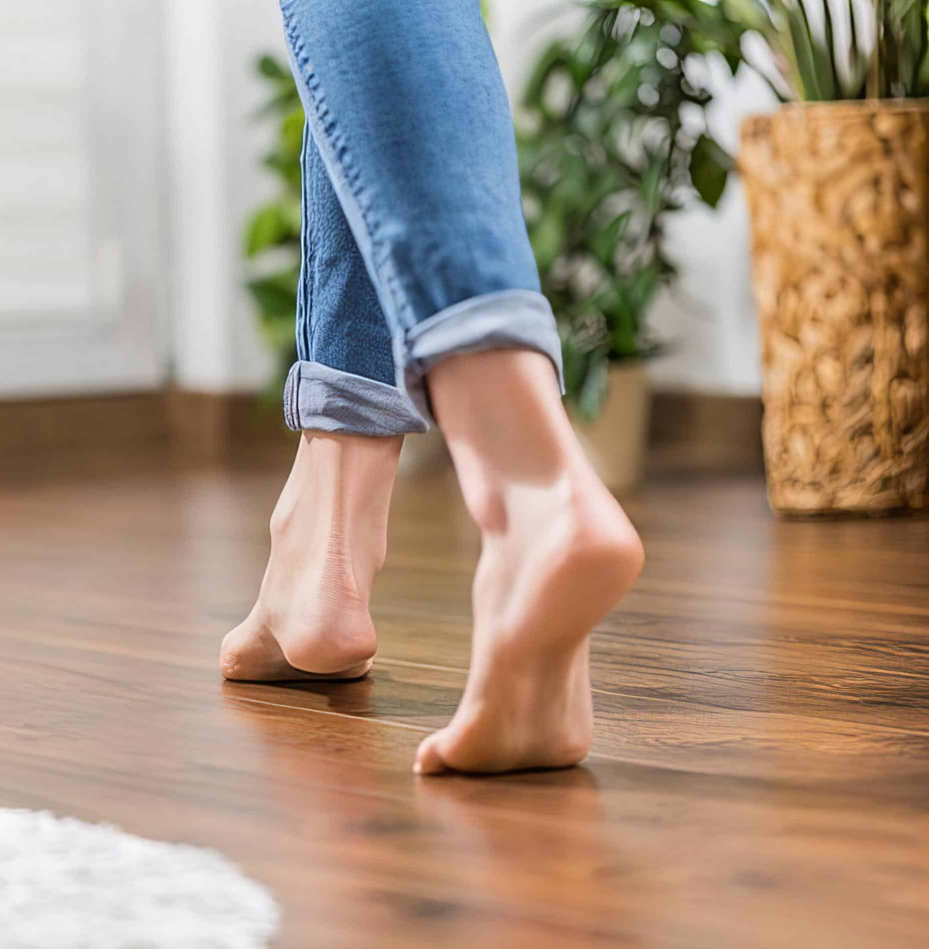 Feet walking on clean wooden floor